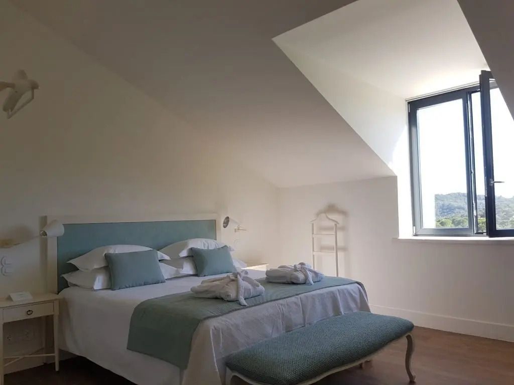 Helles Superior Zimmer mit Doppelbett und Sitzbank unter schrägem Dachfenster