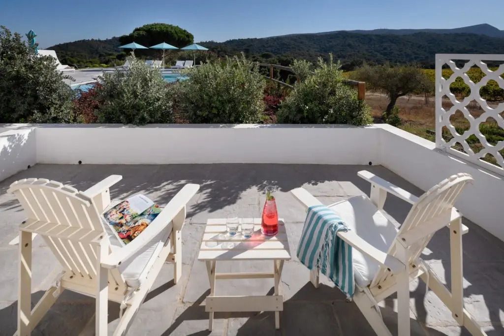Terrassenblick mit Stühlen, Tisch. Landschaft und Pool im Hintergrund
