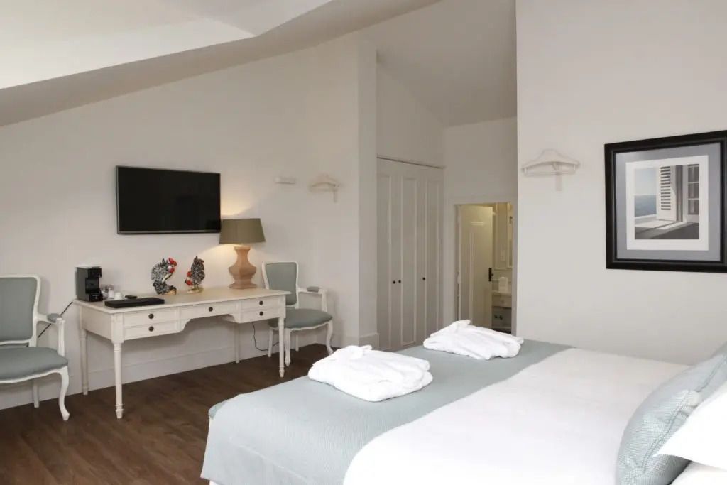 Zimmer mit Schreibtisch, TV und Doppelbett in modernem Design