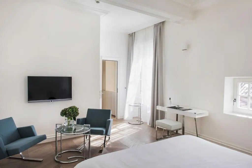 Zimmer mit Sitzbereich, Fernseher und Schreibtisch