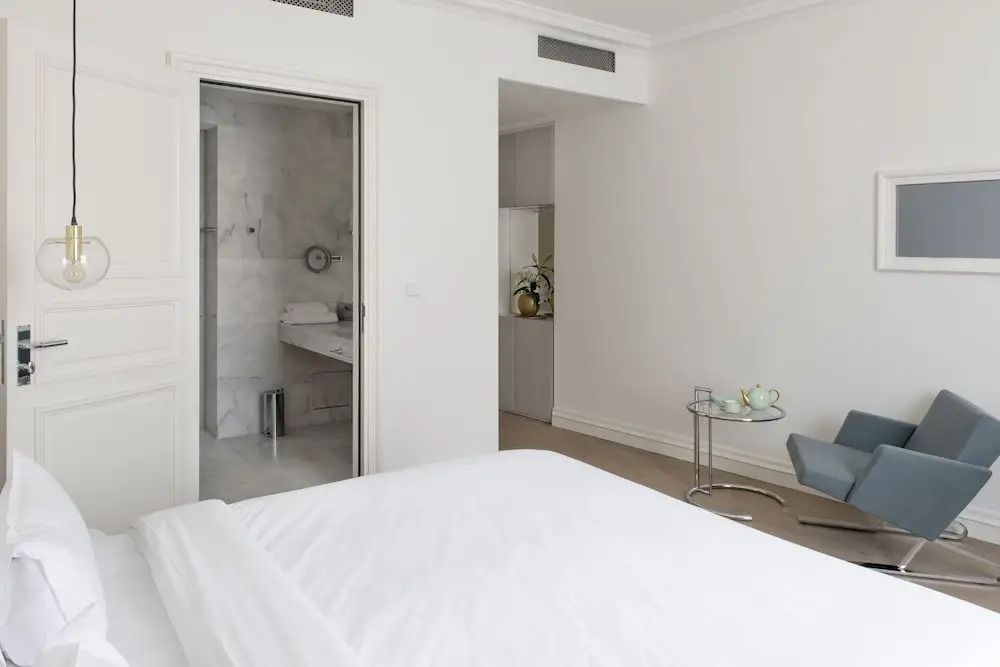 Lichtdurchflutetes Zimmer mit eleganter Einrichtung und Badezimmer im Hotel de Tourrel