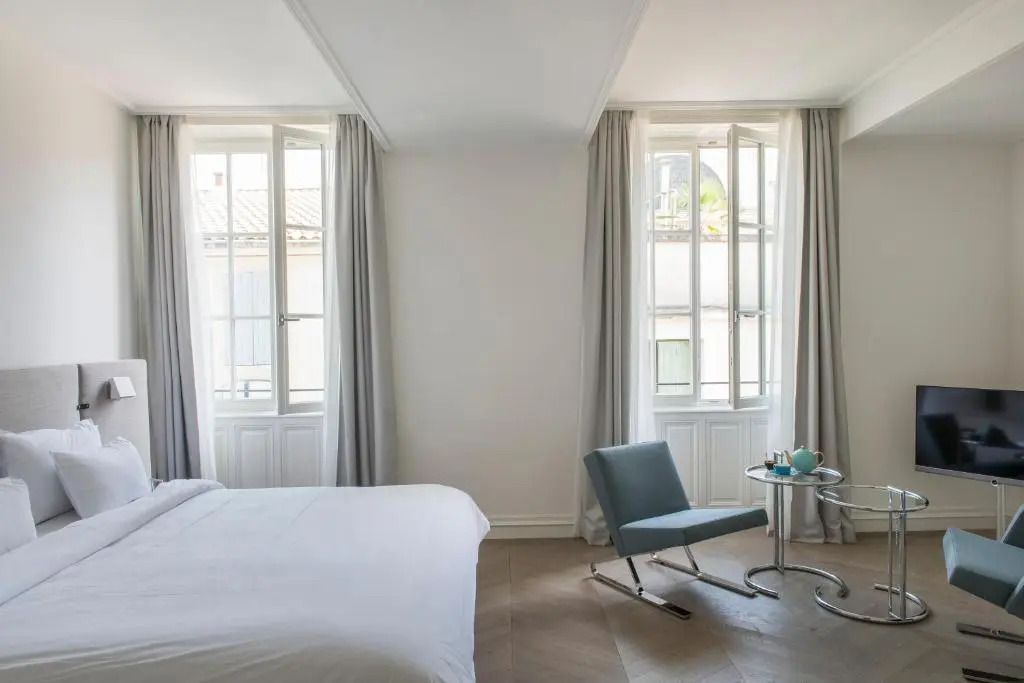Schlafzimmeransicht mit großen Fenstern und modernem Sessel
