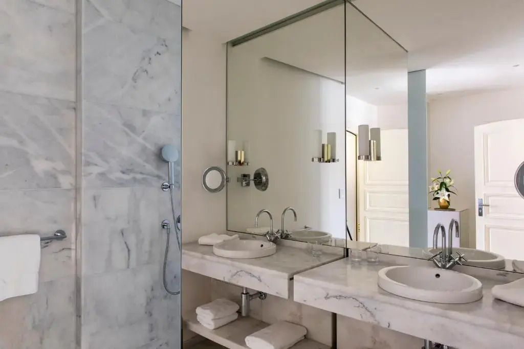 Modernes Badezimmer mit Marmordetails und großzügigem Spiegel