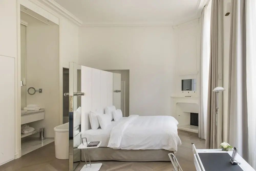 Geräumiges Zimmer mit weißem Bett und modernem Kamin