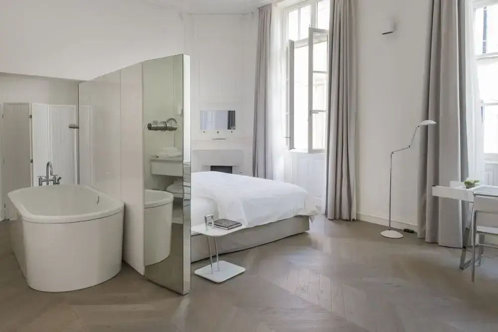 Zimmer mit gemütlicher Leseecke und großen Fenstern