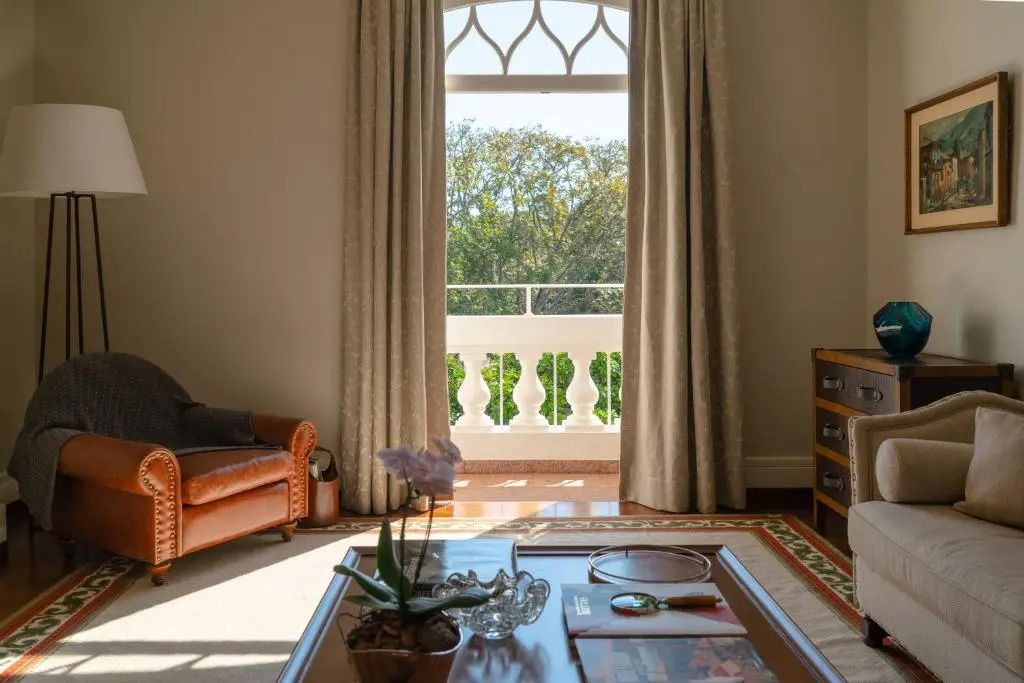 Wohnbereich der Deluxe-Suite mit Ledersessel und Aussicht auf den Garten