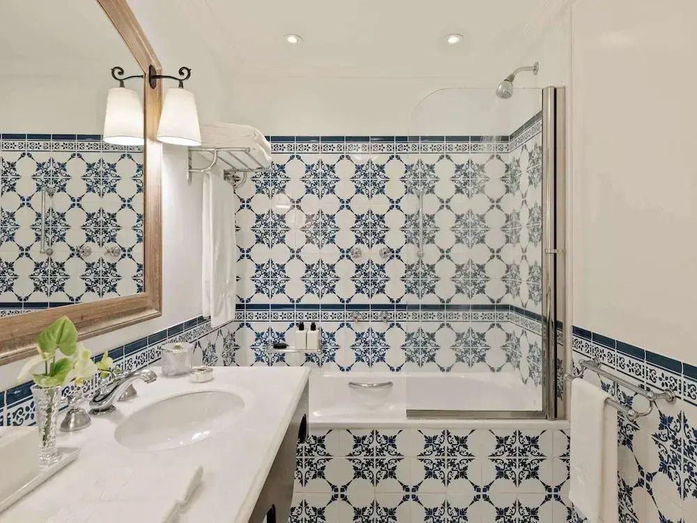 Badezimmer mit blauen und weißen Fliesen und moderner Ausstattung