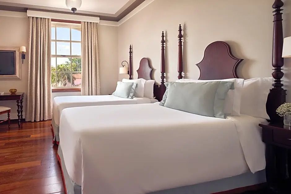 Schlafzimmer mit zwei großen Betten und klassischen Holzelementen