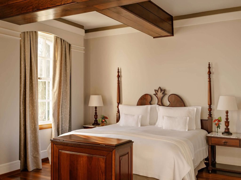 Geräumiges Schlafzimmer mit klassischem Holzdekor und großen Fenstern.