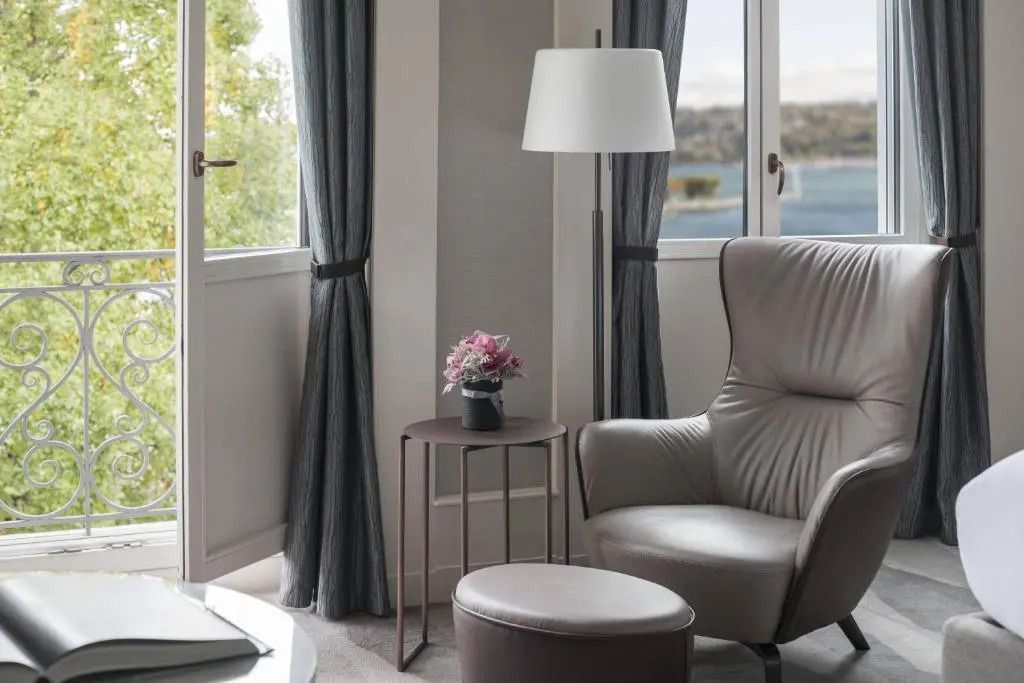Sitzecke mit Sesseln und Seeblick im Deluxe Zimmer in Genf.