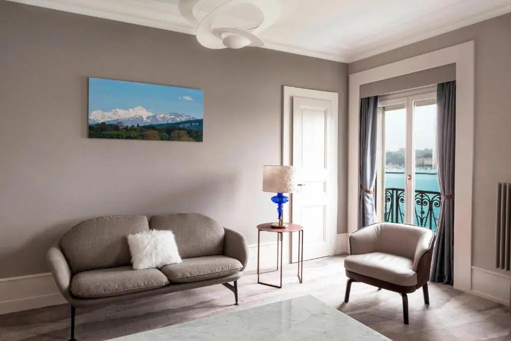 Elegantes Wohnzimmer mit Sofa und Tür zum Balkon mit Seeblick