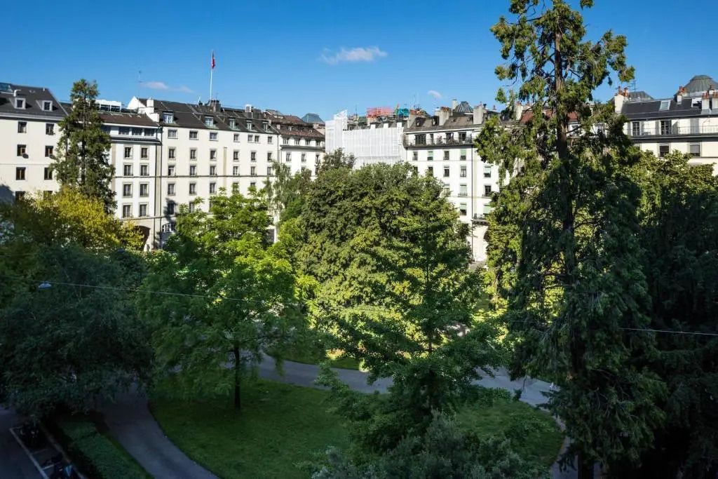 Blick aus der Suite auf einen grünen Garten und umliegende Gebäude.