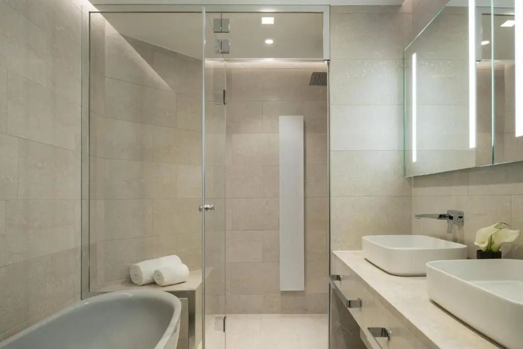 Modernes, elegantes Badezimmer mit Glasdusche und neutralen Farbtönen.