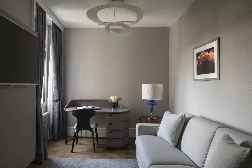 Moderner Wohnbereich einer Suite mit Schreibtisch und bequemer Couch.