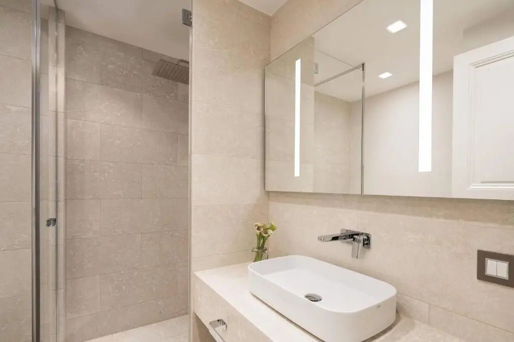 Modernes Badezimmer mit stilvollem Waschbecken und großer Dusche im Ritz-Carlton Genf.