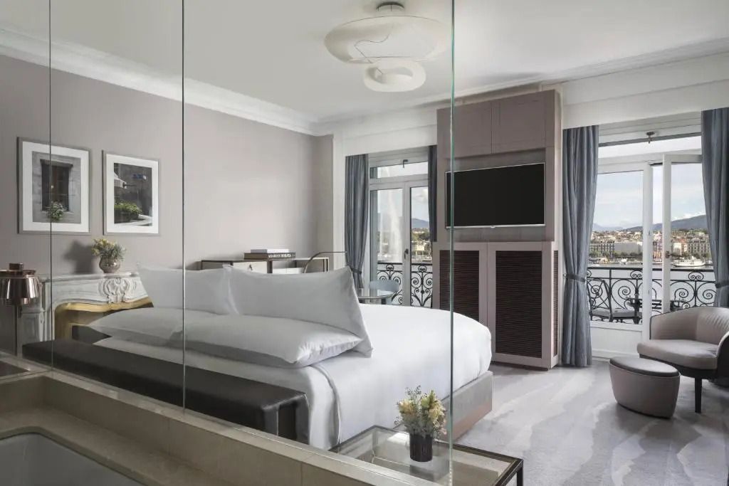 Elegantes Schlafzimmer mit großen Fenstern und Blick auf den See