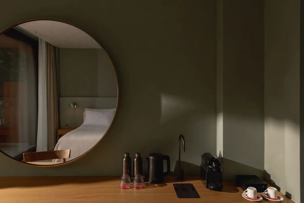 Moderne Einrichtung mit Rundspiegel im Deluxe Einzel Zimmer mit Balkon
