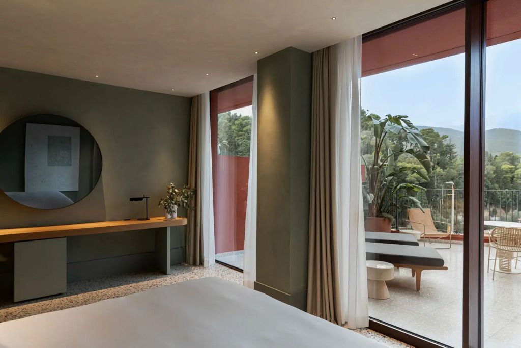 Modernes Zimmer mit eleganter Einrichtung und großem Balkon mit Blick ins Grüne.