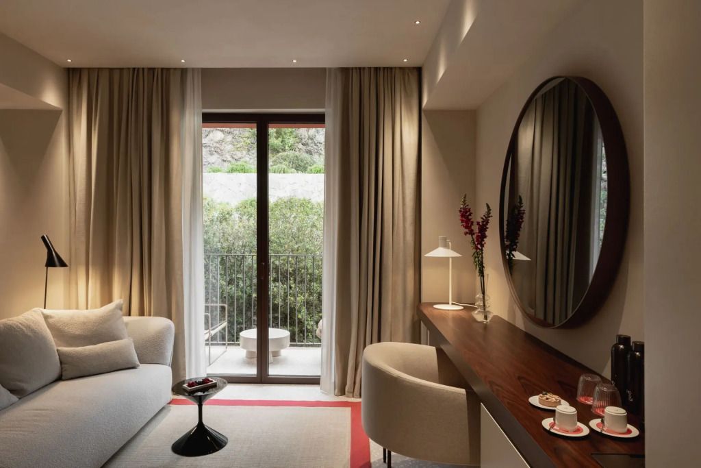 Helle Suite mit Sitzbereich und Blick auf einen begrünten Garten
