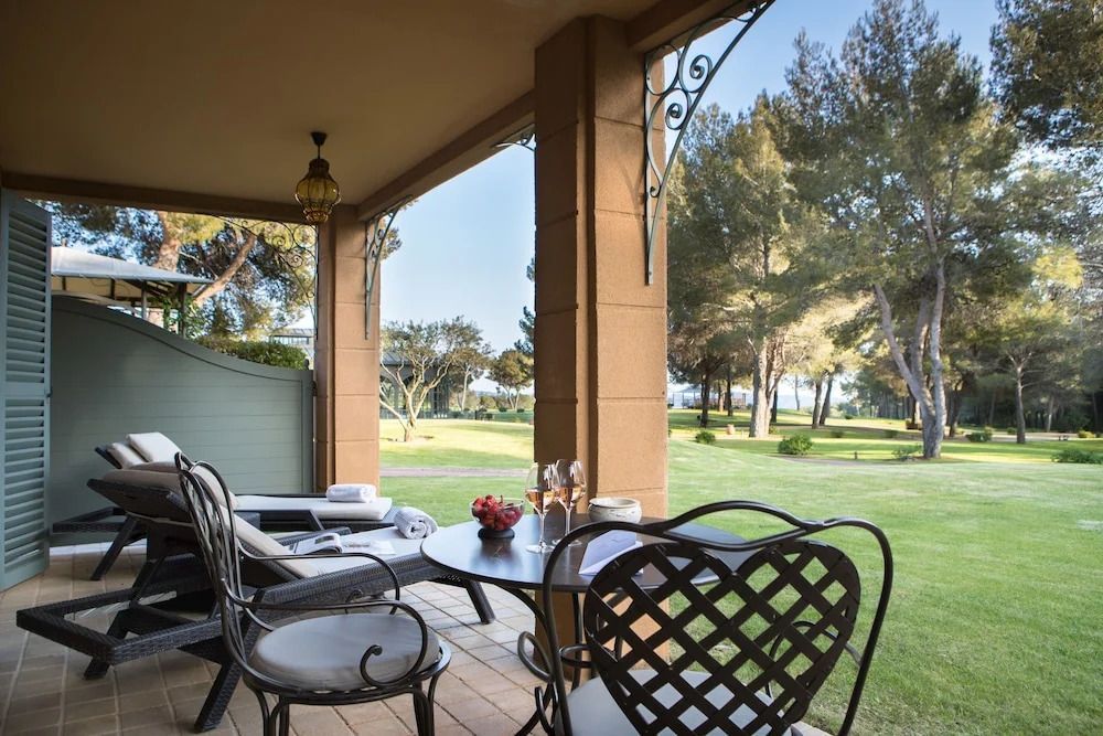 Terrasse mit eleganter Sitzgelegenheit und Blick auf gepflegten Garten im Hotel.