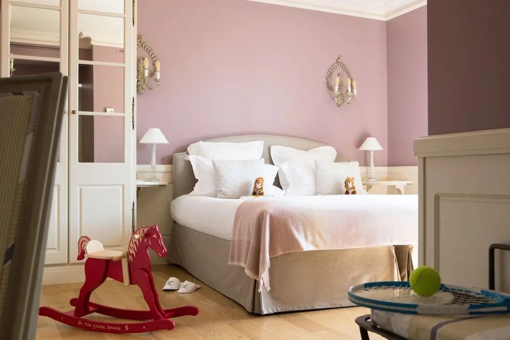Gemütliches Schlafzimmer mit pastellfarbenen Wänden und dekorativem Schaukelpferd.