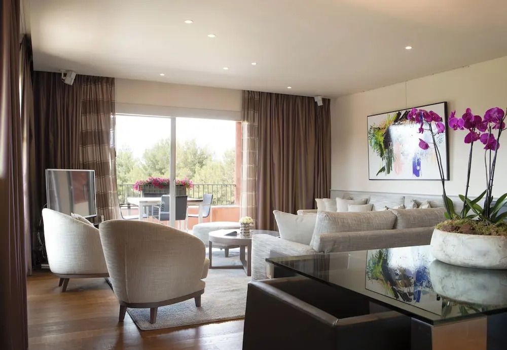 Geräumiges Wohnzimmer mit Sofa und Blick auf Balkon mit Blumen