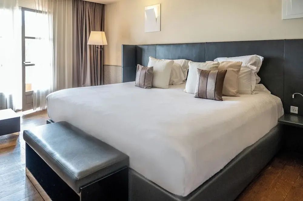 Großes Doppelbett mit vielen Kissen in modernem Zimmer