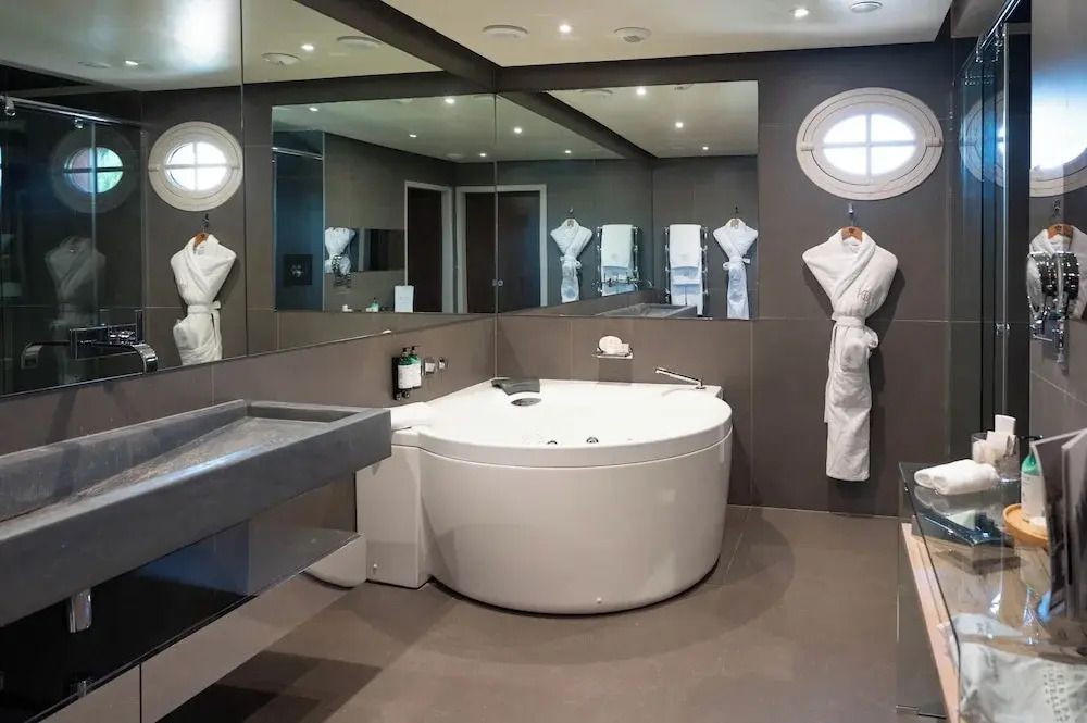 Moderne Hotelsuite Badezimmer mit runder Badewanne und Bademänteln