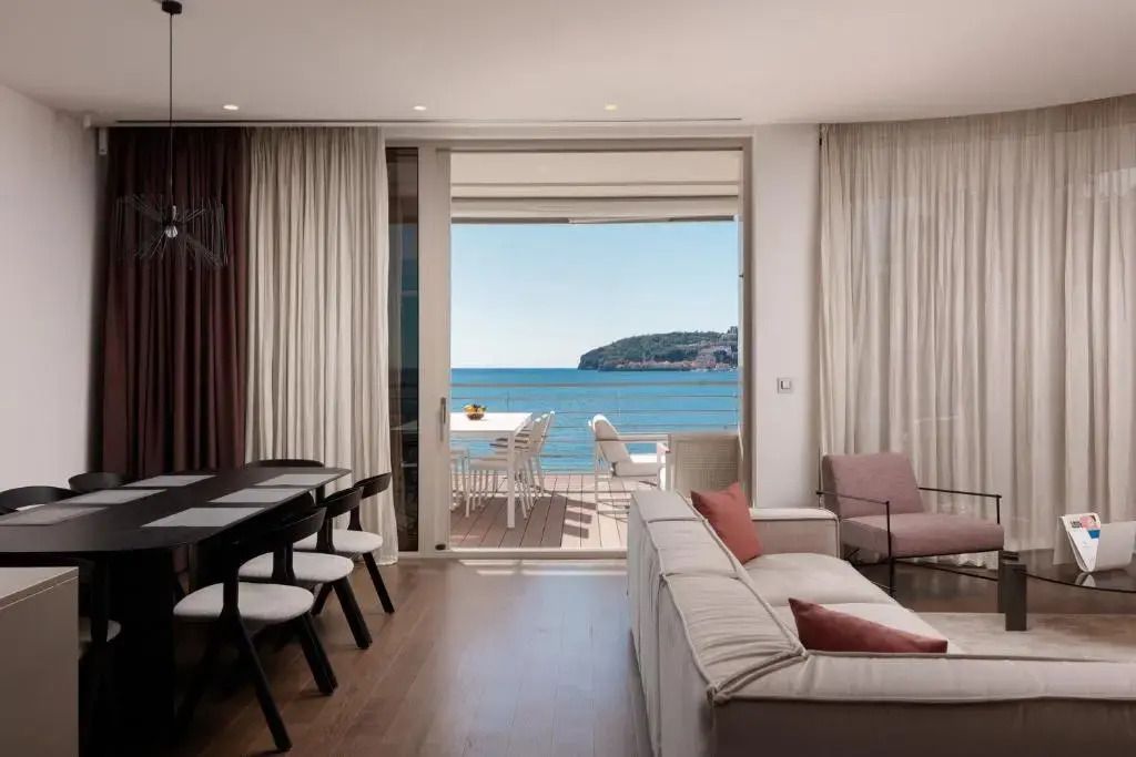 Wohnzimmer mit Zugang zu einem Balkon und Meerblick im ĀNANTI Resort Montenegro