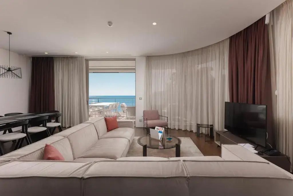 Wohnbereich in einem Apartment mit Zugang zu einer Terrasse und Meerblick