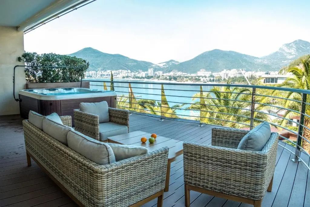 Geräumiger Balkon mit Meerblick und gemütlichen Sitzmöbeln im ĀNANTI Resort Montenegro