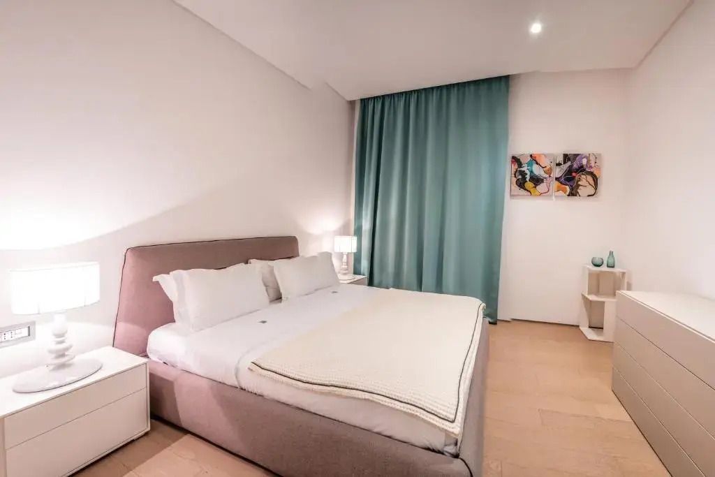 Elegantes Schlafzimmer mit Doppelbett und modernen Kunstwerken im Deluxe Apartment