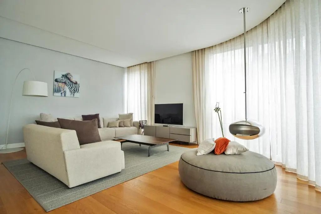 Helles Wohnzimmer mit modernen Möbeln und einem großen Fernseher