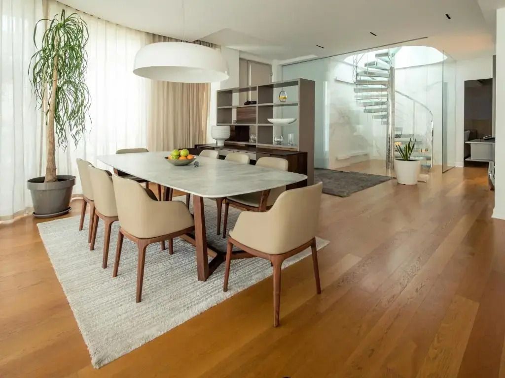 Essbereich mit großem Tisch und eleganten Stühlen in hellem Raum
