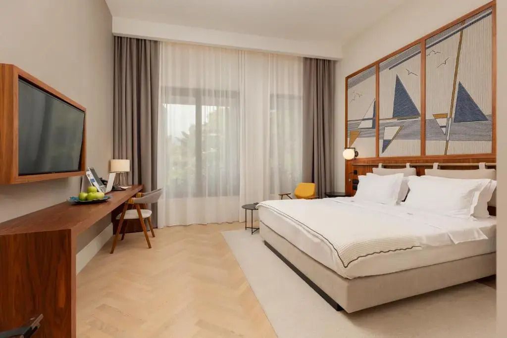 Elegantes Superior Zimmer mit Doppelbett und stilvoller Wandkunst im ĀNANTI Resort