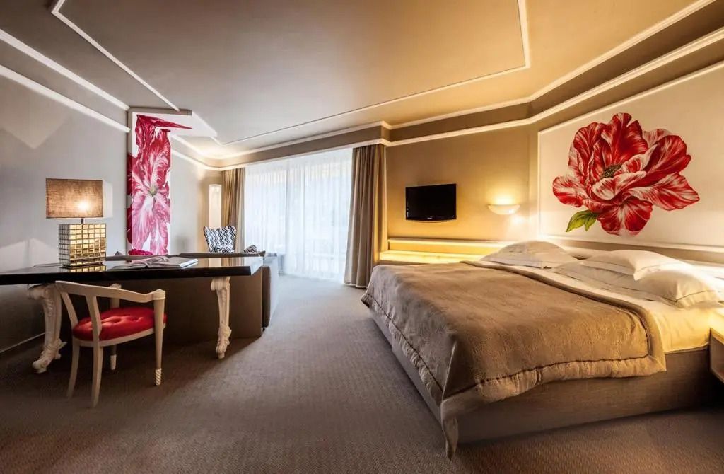 Großzügiges Deluxe Doppelzimmer mit stilvoller Wanddekoration und TV