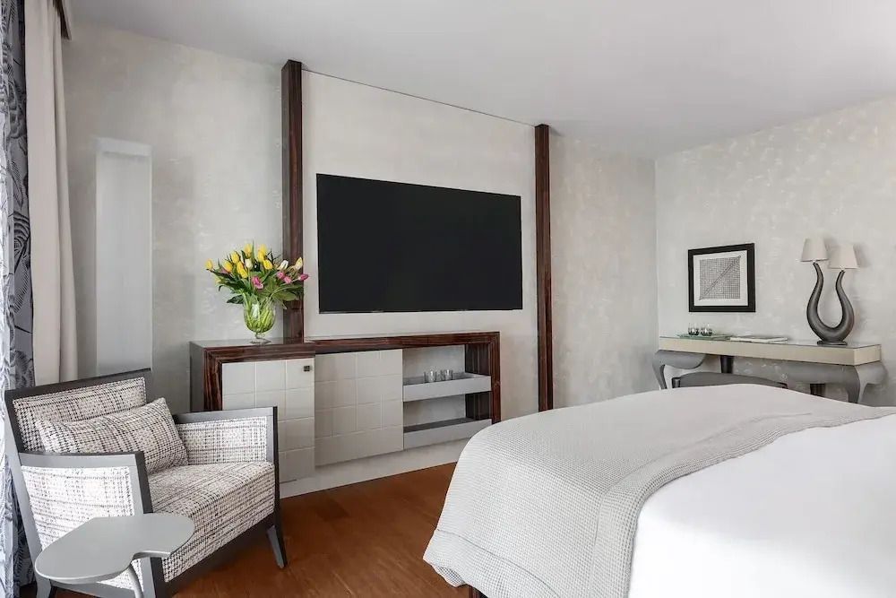 Modernes Zimmer mit großem Flachbildfernseher und gemütlichem Sessel