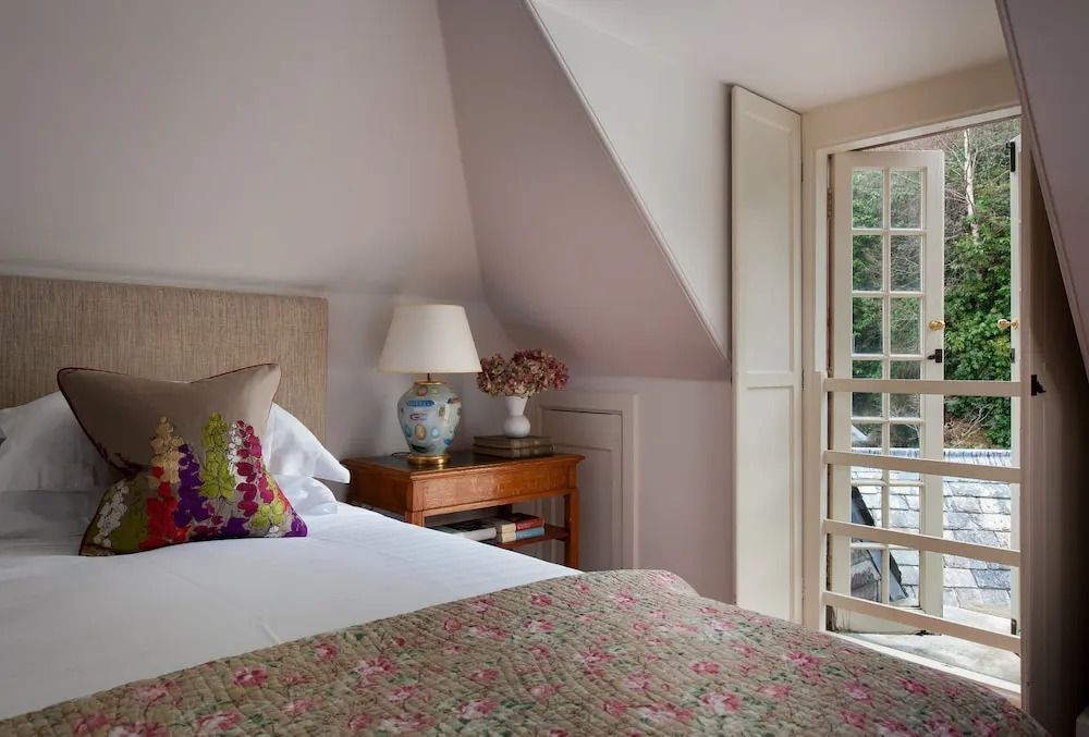 Doppelzimmer mit großen Fenstern und floralen Dekoelementen