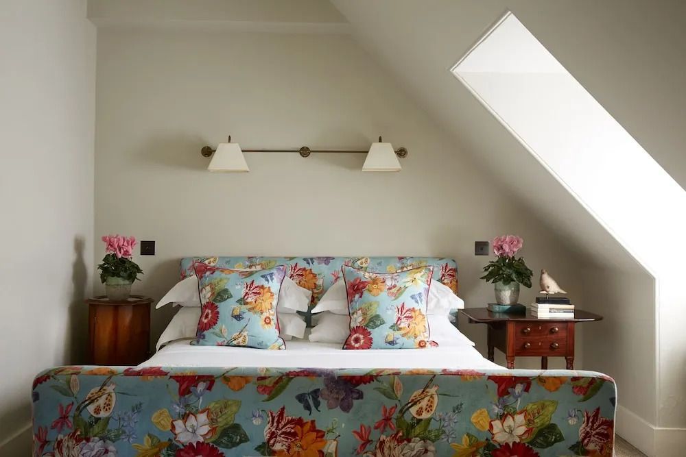 Doppelbett mit leuchtend geblümten Bettbezügen und Kopfteil