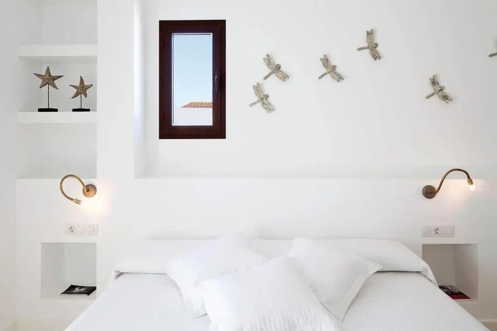 Weißes Zimmer mit Dekorationselementen an der Wand und kleinem Fenster