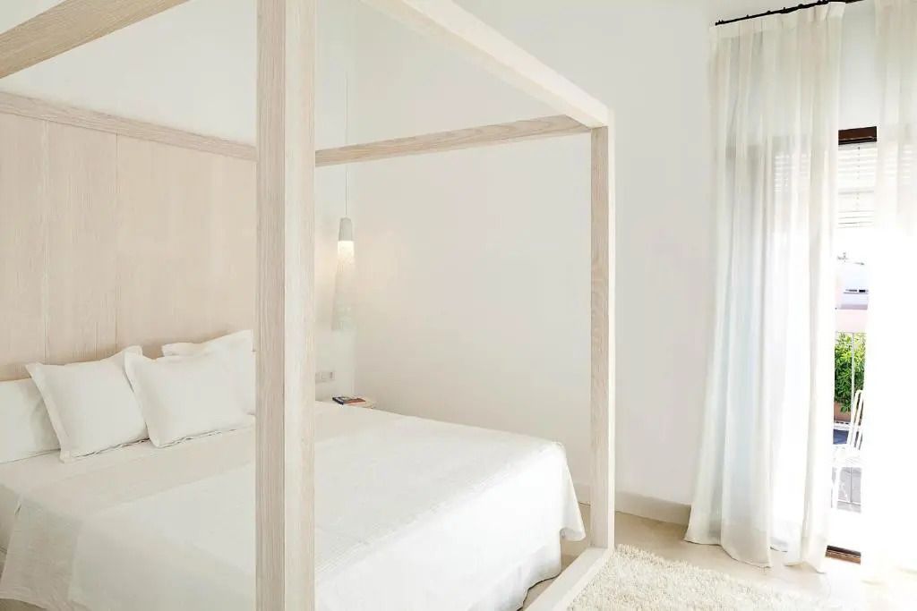Zimmer mit Himmelbett-Design in sanfter Farbgebung und Vorhängen