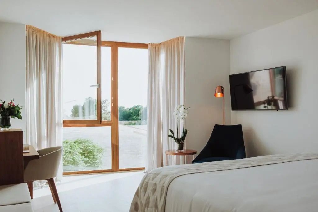 Helles Zimmer mit Blick aufs Meer durch große Fenster, modern eingerichtet.