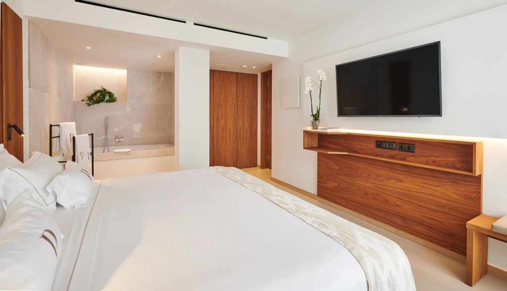 Modernes Schlafzimmer mit großem Doppelbett und Flachbildfernseher