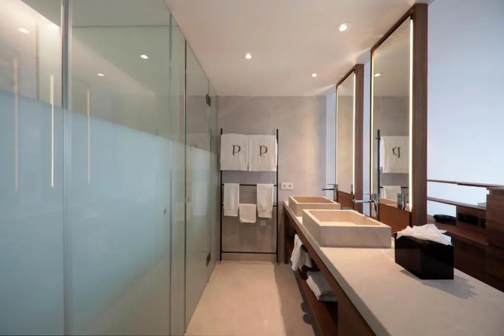Modernes Badezimmer mit Doppelwaschbecken und eleganter Glasdusche