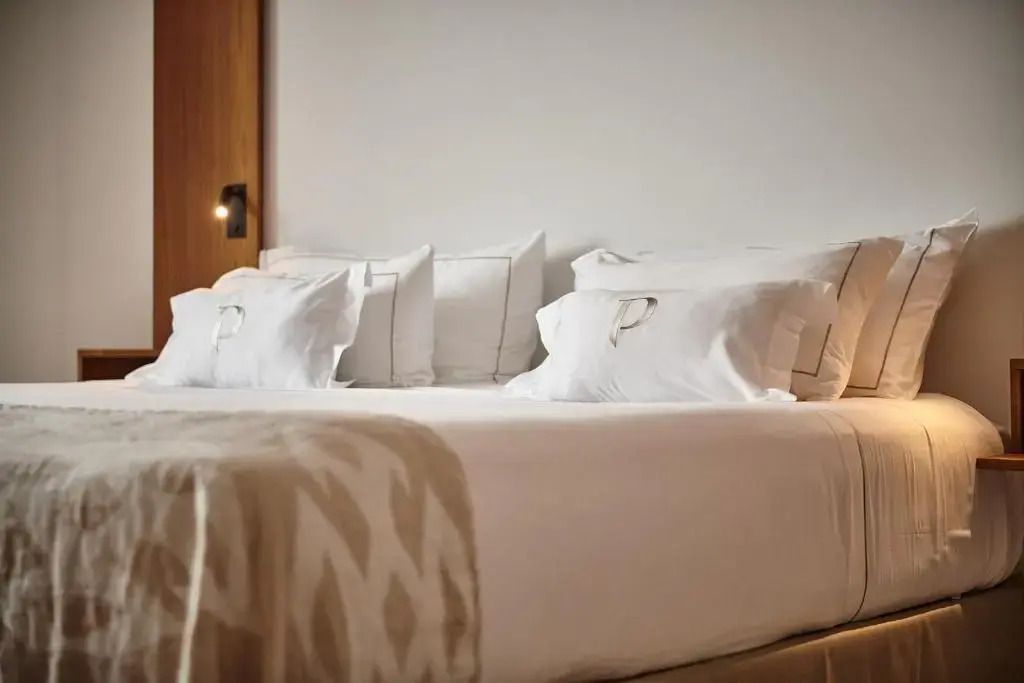 Hochwertiges Bett mit weichen Kissen und dekorativer Tagesdecke im Superior-Zimmer.