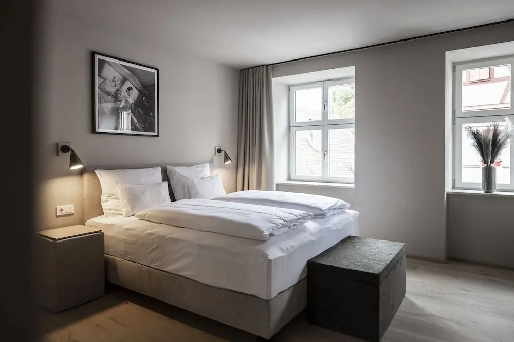 Modernes Schlafzimmer in neutralen Farben mit Kunstwerk an der Wand