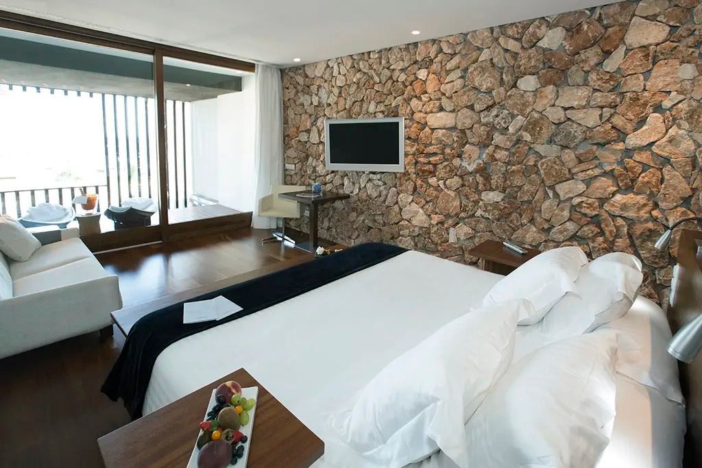 Doppelzimmer mit Natursteinwand und Balkon im Hotel Hospes Maricel