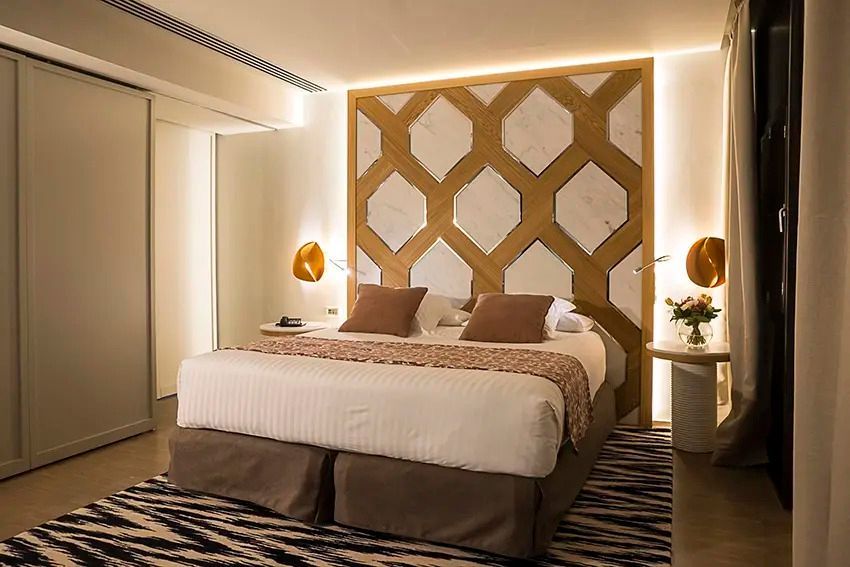 Elegantes Doppelzimmer mit stilvollem Kopfteil und warmen Beleuchtungseffekten