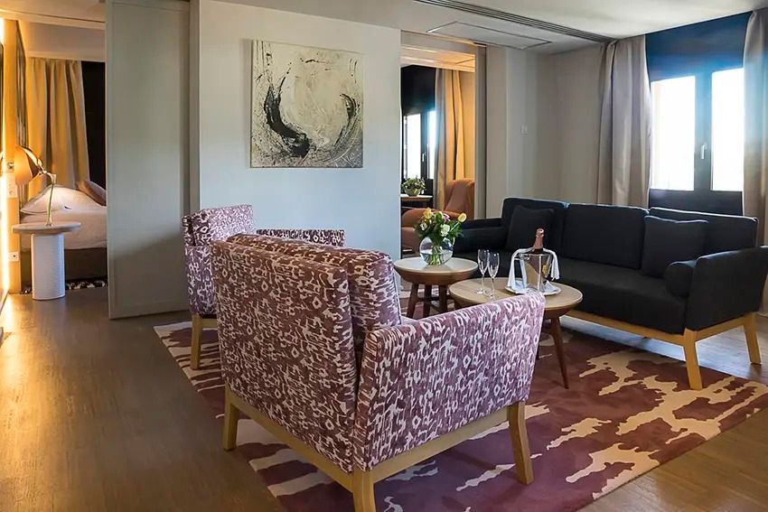 Gemütlicher Wohnbereich mit Designer-Sesseln und moderner Kunst an der Wand