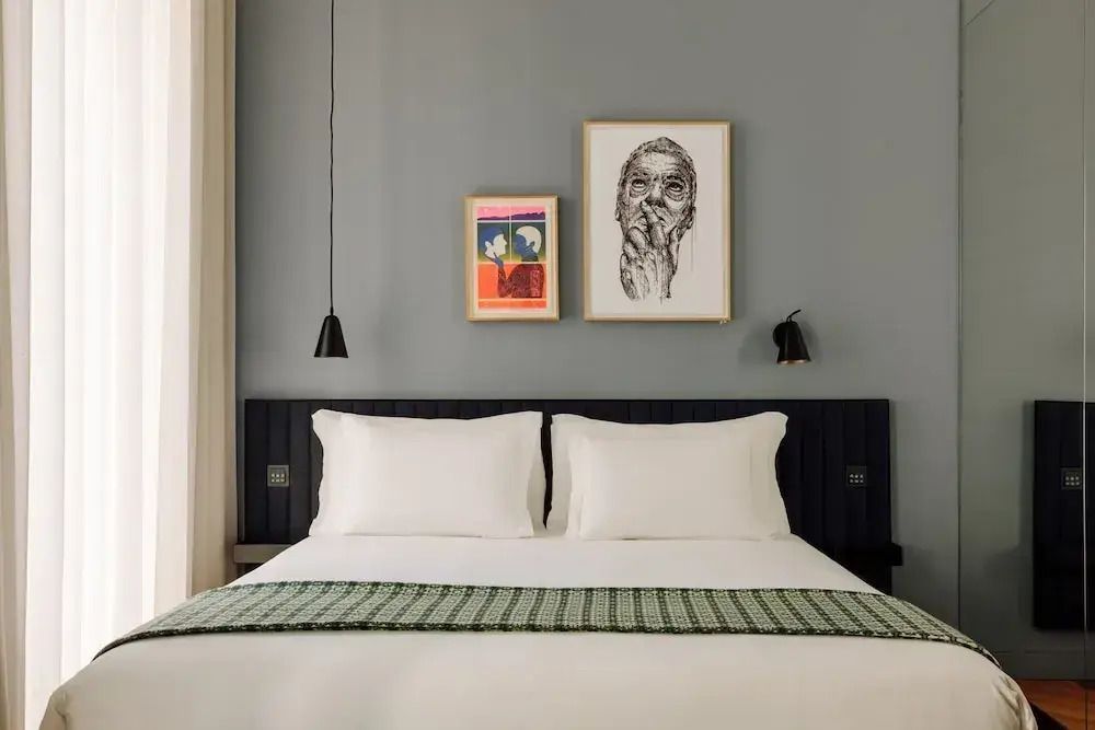 Junior-Suite mit stilvollem Doppelbett und Kunstwerken an der Wand